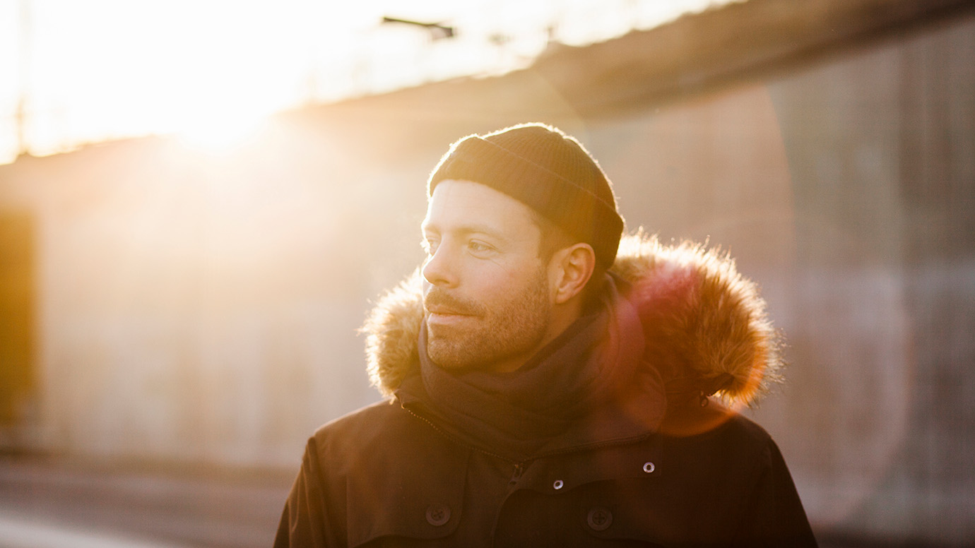 Man wearing jacket looking away on sunny day